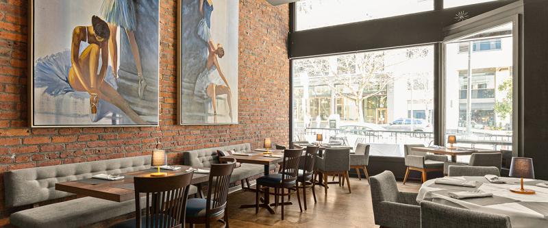 Elegant restaurant interior with large paintings.