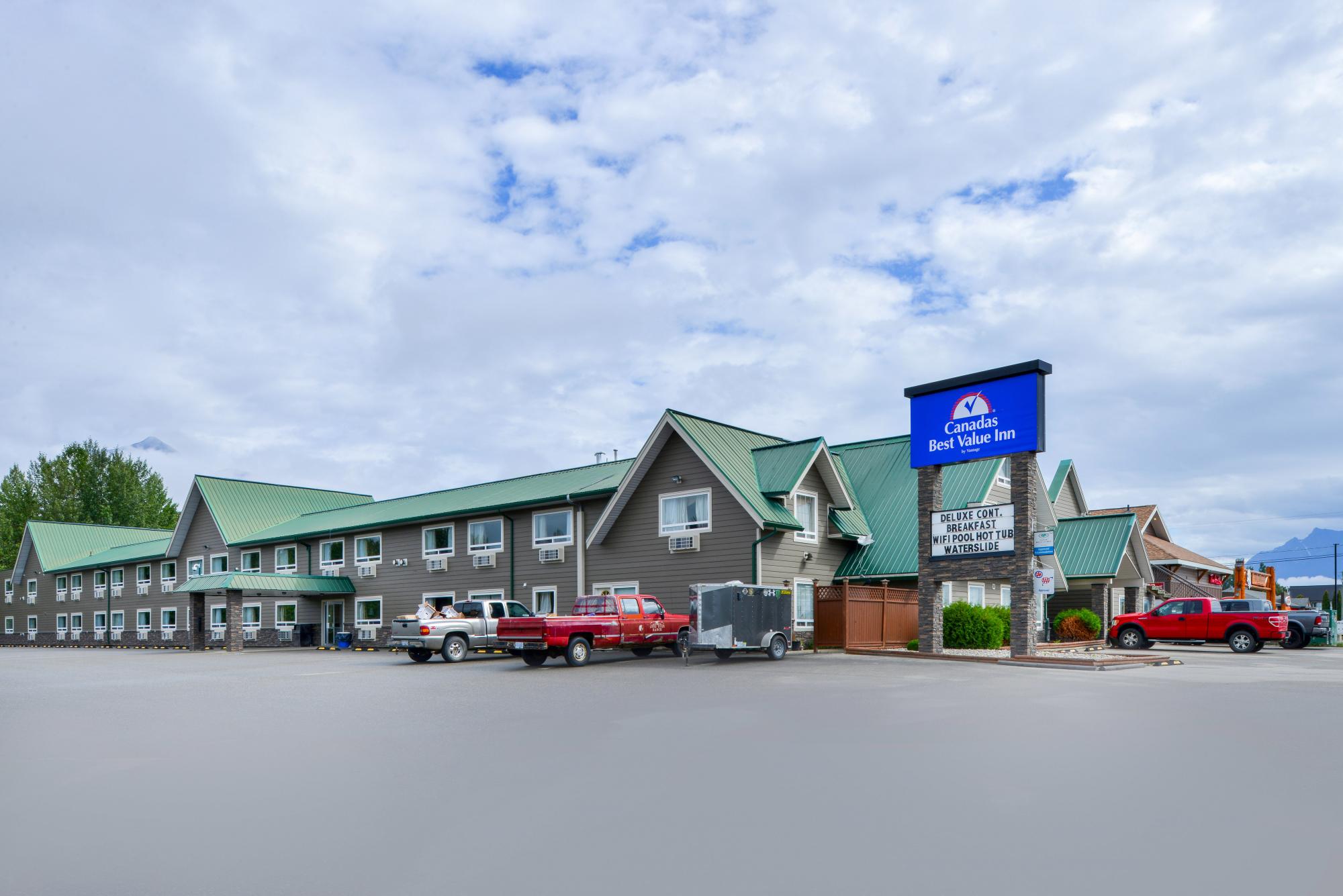 Hotel exterior and parking lot with sign