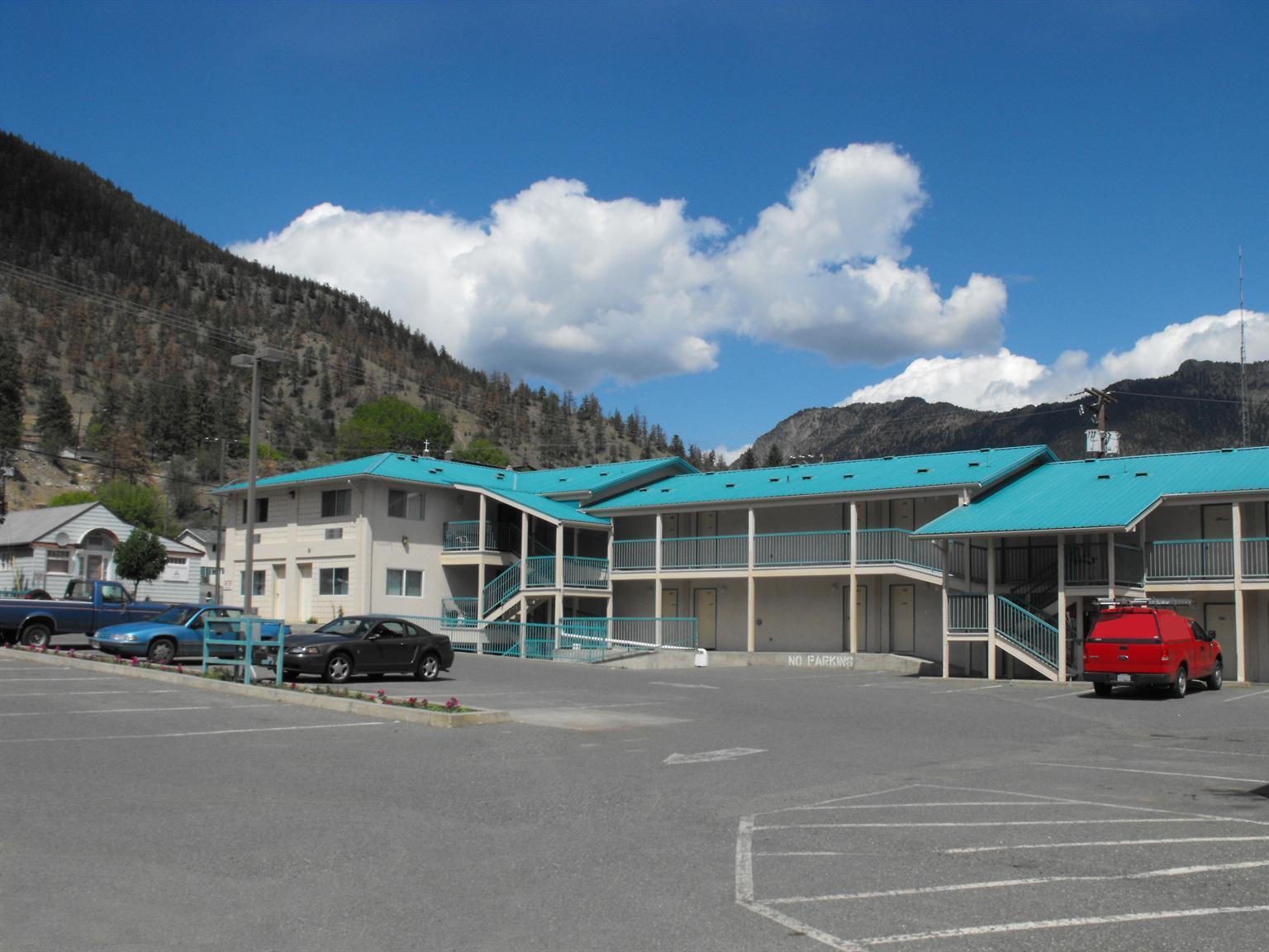 Hotel exterior with parking lot and hill top behind