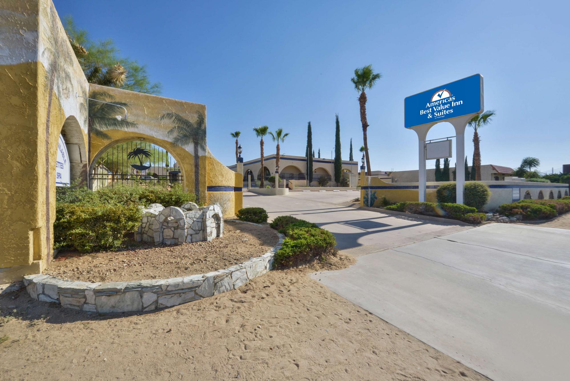 Street view of hotel exterior with sign and palm trees