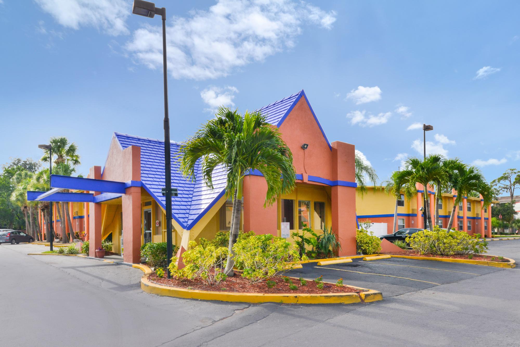 Entry exterior with palm trees and parking