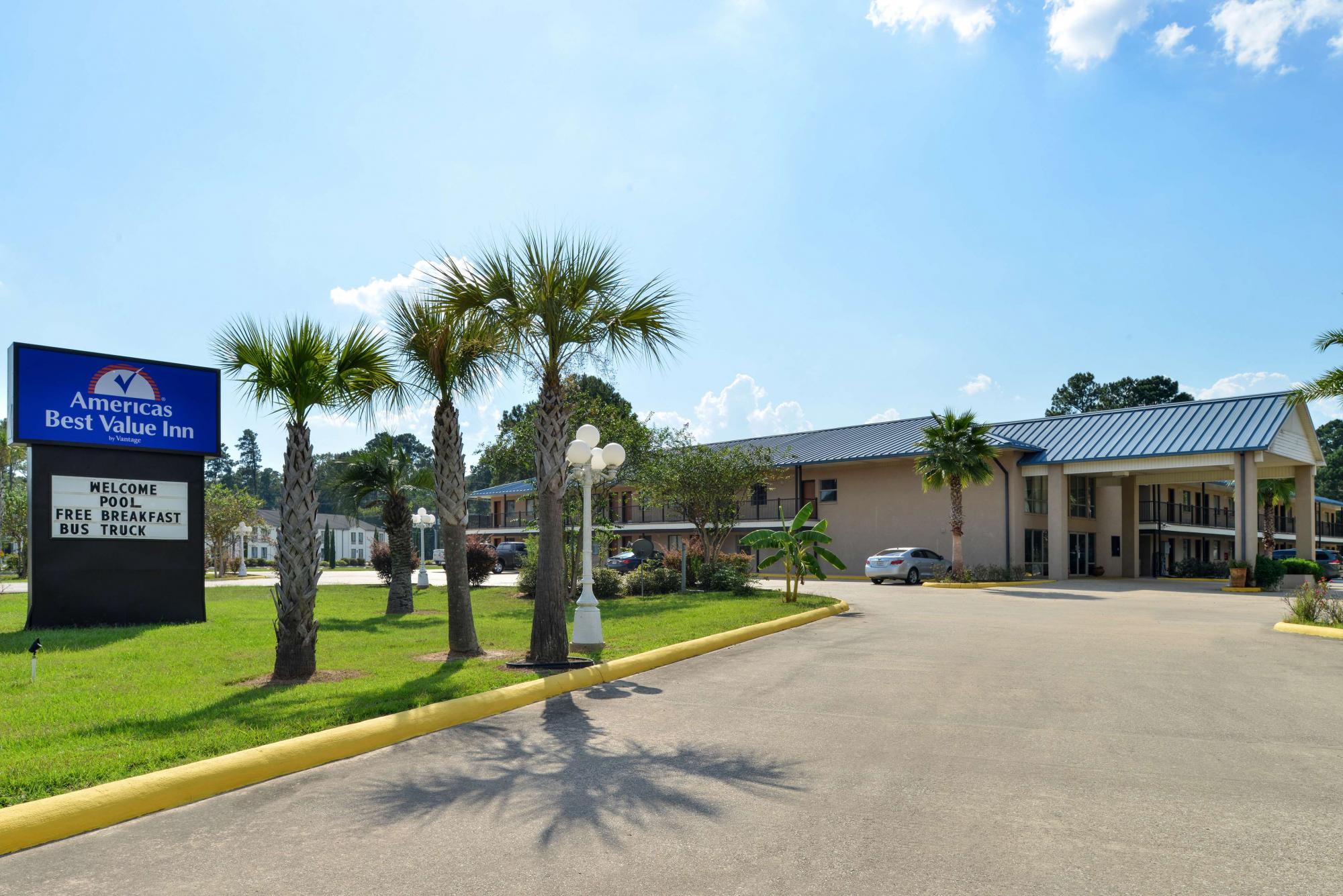 Street view of hotel entrance exterior with lawn area