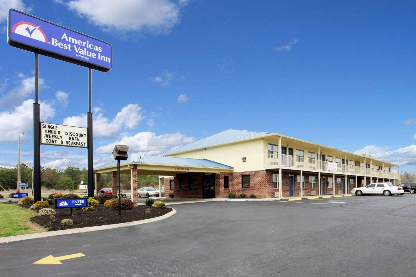 Hotel exterior with ample parking and sign