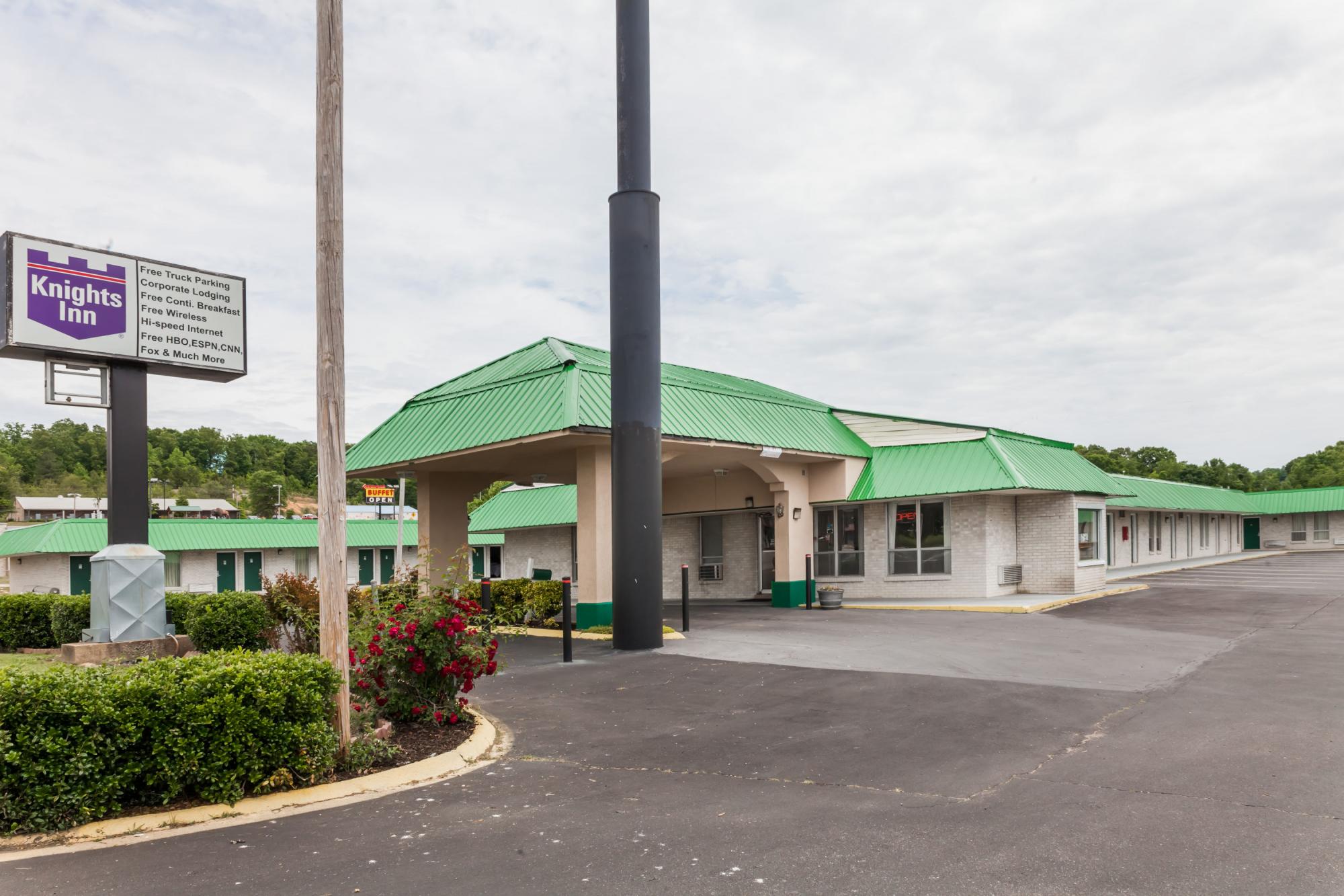 Exterior With Large Parking Lot and Hotel Sign