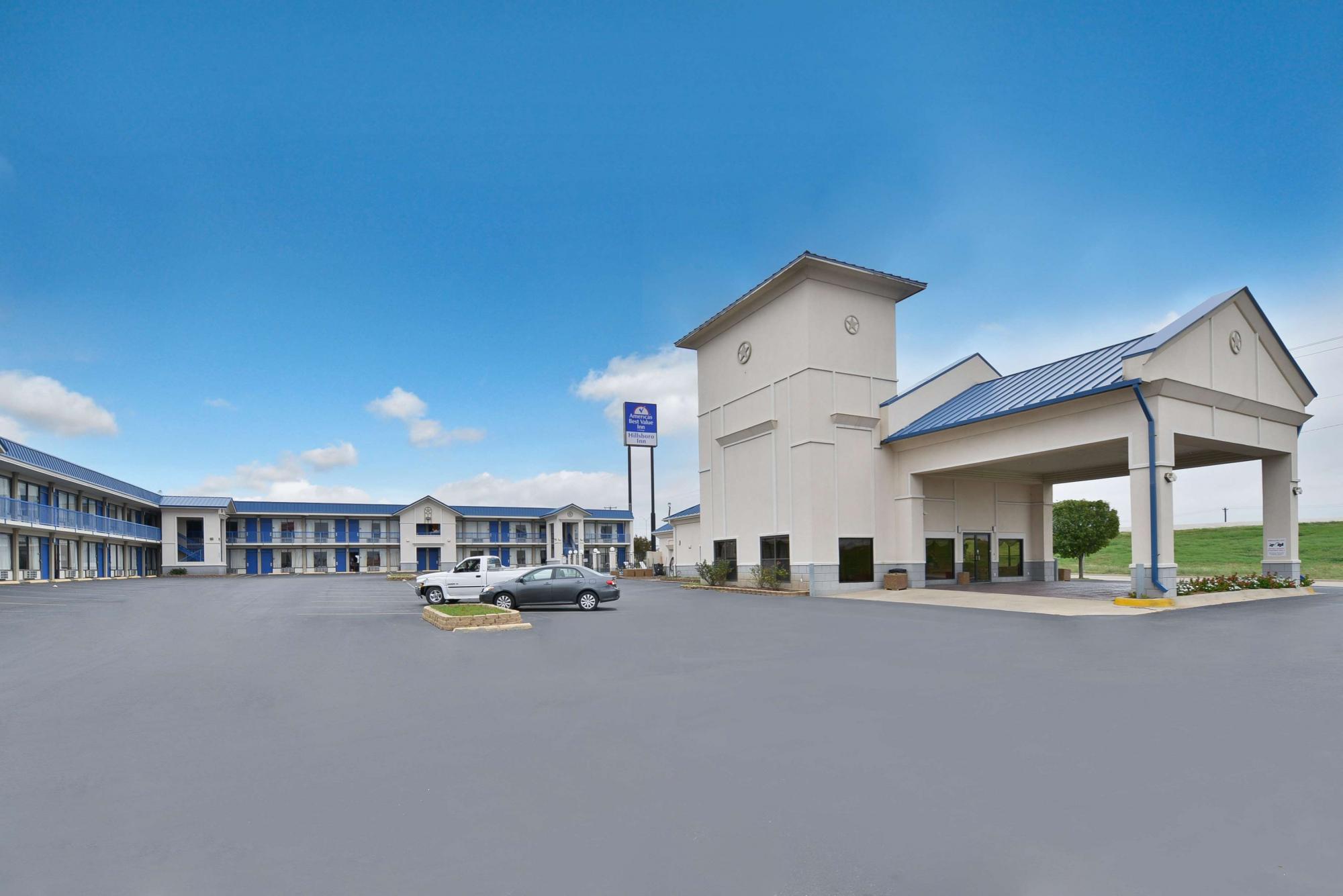 Parking lot view of hotel exterior with ample parking