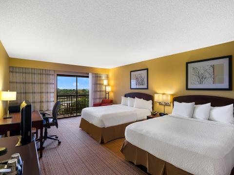 Guest room with queen beds and walk out balcony at Sonesta Select Dallas Richardson.