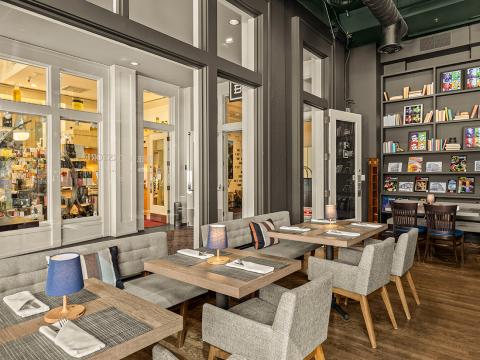 Modern café interior with bookshelves and grey seating.