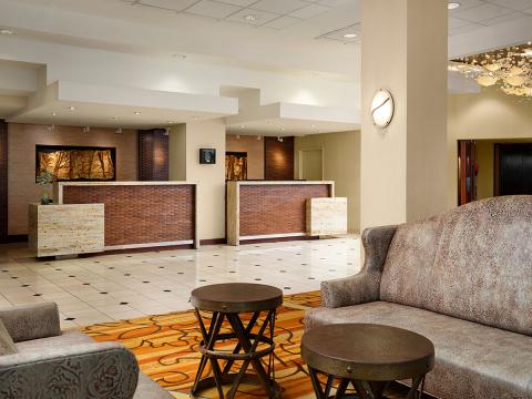 Hotel reception area with brown counters and tiled floor.