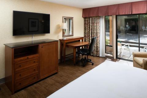 Spacious King guest room with desk, armchairs and flatscreen TV