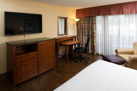 Spacious King guest room with desk, armchairs and flatscreen TV
